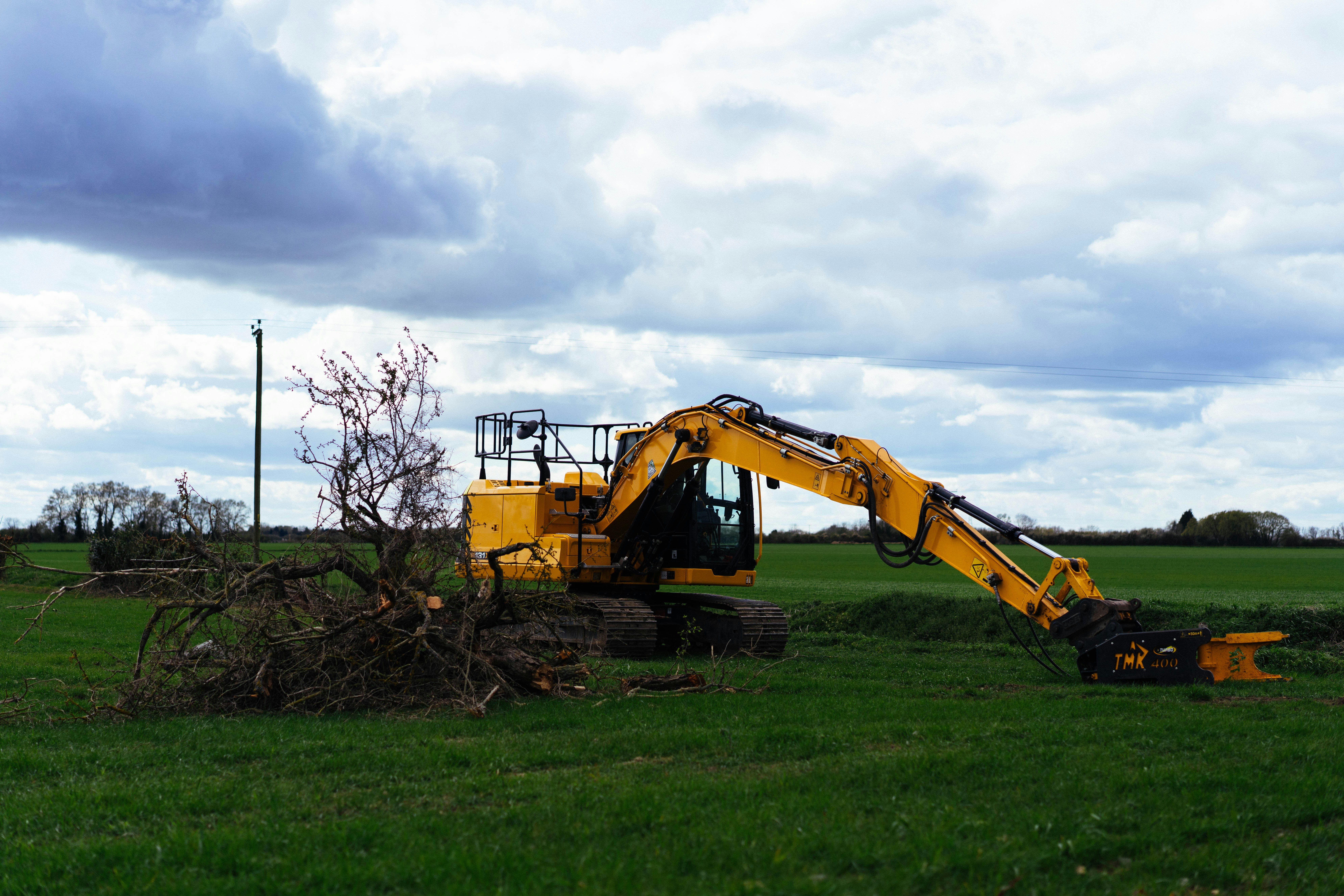 Excavator clearing a field